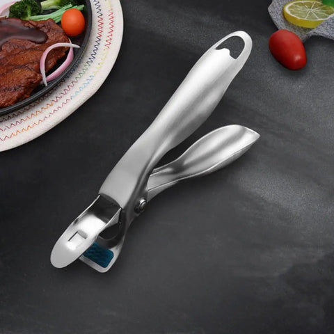 Heavy Duty Stainless Steel Plate Lifter Clamp With A Rock Solid Grip And Smart Anti Scald Bow Clip For Zero Stress Hot Casserole Handling In Your Kitchen on a black surface.