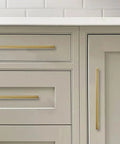 Six Pack 6 Inch Center To Center Brushed Brass Cabinet Pulls installed on kitchen drawers and cabinets showing antique style hardware.
