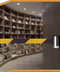 Slick Wall Mounted Retractable Warning Belt With Auto Magnetic Lock, Built Tough Five Meter Yellow And Black Barrier mounted in a library.