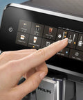 Touching the display of a Fully Automatic Espresso Machine With LatteGo Milk System For Pro Grade Silky Froth And 5 Coffee Varieties Intuitive Touch Display SilentBrew 100 Percent Ceramic Grinder AquaClean Filter Glossy Black