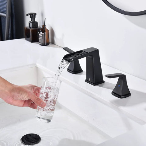 Matte Black Waterfall Bathroom Faucet For 8 Inch Widespread Sink Three Hole Two Handle Vanity Faucet With Pop Up Drain No Splash Quiet Operation and Durable Finish For Modern Home Bathrooms in use, pouring water into a glass.