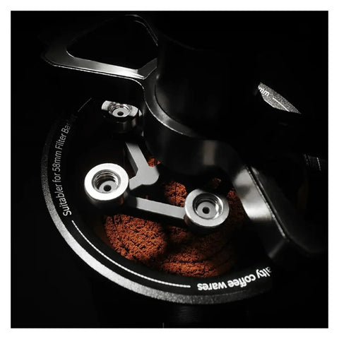 Close-up of 58mm stainless steel magnetic WDT tool distributing coffee grounds for balanced saturation.