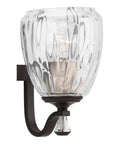 Close-up of Anjoux Collection 3-Light Clear Water Glass Luxe Bath Vanity Light in Antique Bronze, showing glass texture.
