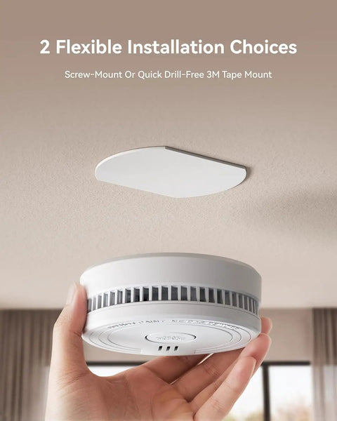 Hassle Free Smoke Detector Designed With Adaptive Sensing To Slash Nuisance Alerts While Delivering Dependable Household Fire Protection Runs Smooth On A Single Nine Volt Battery Offers Quick Easy Wall Install, shown in hand with 3M tape mount.