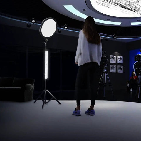 Person in a studio with professional lighting, featuring 4 Piece LED Light Boards With 2 Dimmable Power Adapters For Product Photography Light Box.