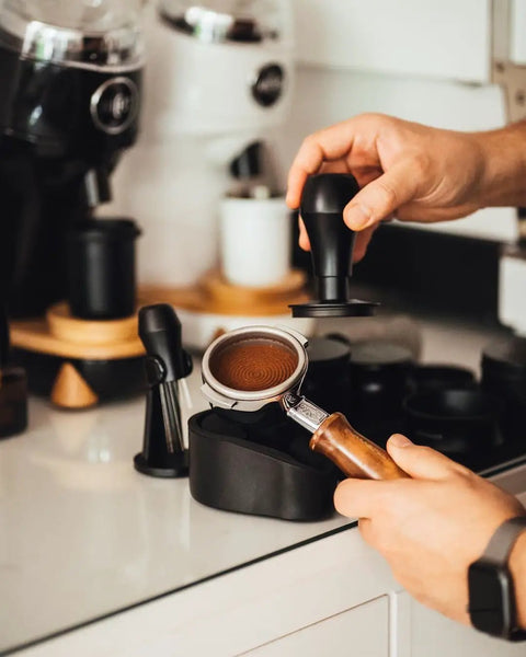 Person using Portafilter Holder And Tamping Station For Espresso, 304 stainless steel with silicone holder for 58mm portafilters.
