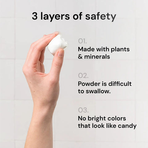 Hand holding a Sixty Three In One Laundry Detergent Pod, emphasizing its plant-based safety features.