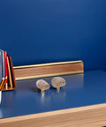 Dope Irregular Pebble Stone Cabinet Handles With Brass Base for furniture and home decor on a blue desk