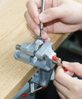 360 Degree Rotating Mini Bench Vise Clamp for Crafting and Jewelry Making on a Table Mount with hands adjusting jewelry