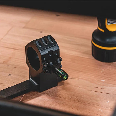 One Piece Bolt Action Scope Mount With Thirty Mil Medium Rings For Remington Seven Hundred Short Action showing level adjustment on a wooden surface.
