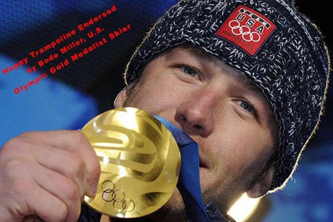 Person holding gold medal and wearing USA Olympic hat, text reads 'Happy Trampoline Endorsed by Olympic Gold Medalist Skier.'