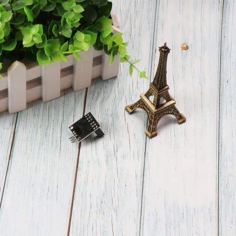 Six Pack LM393 H2010 Photoelectric Infrared Sensor Module For Arduino Projects next to Eiffel Tower model on wooden surface.