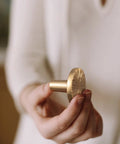 Close-up of Champagne Bronze Cabinet Knob, 1.1 inch diameter, zinc alloy, held in hand, part of a 6 pack for kitchen cabinets and wardrobes.