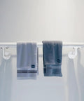 Built Like A Tank Two Foot White Steel Stair Railing With Heavy Duty Wall Mount Brackets To Keep Your Footing Locked Down On Indoor And Outdoor Steps As A Senior Grab Bar with two gray towels hanging.