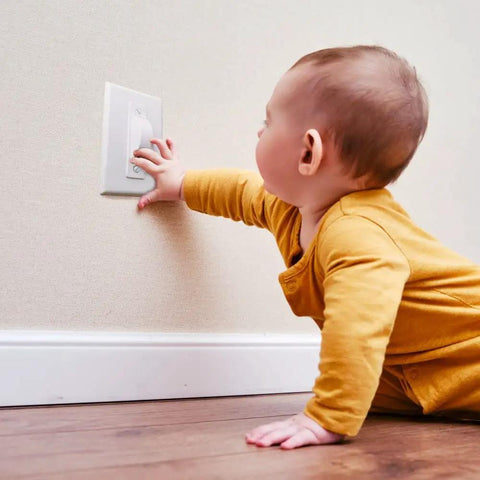 Childproof Light Switch Plate Covers 2 Pack White Safe Home Shield To Stop Little Ones And Curious Adults From Accidentally Flipping The Switch Easy Install Toggle Switch Shields shown being reached by a child