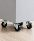 Close-up of Four Pack Heavy Duty Flat Top Plate Caster Wheels with Poly Tires on a utility cart on a wooden floor.