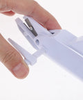 Hand holding safety lock feature of cordless electric scissors for fabric cutting handheld sewing tool.