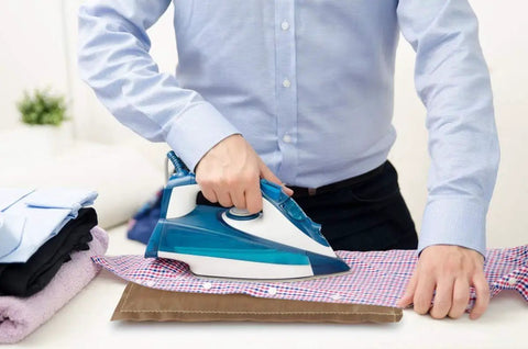 Person using iron on plaid shirt with Heat Press Pillow Kit With Four Mat Sizes And Five Rulers For Vinyl And Sublimation Transfers.