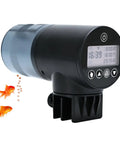 Smart Wireless Fish Feeder With App Control And Timer For Aquariums Three Port Dry Food Dispenser close-up with digital display and feeder slot.
