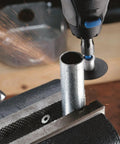 Dremel EZ Lock cutting accessory in use on a metal tube clamped in a bench vise.