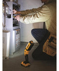 Person using 20V Max LED Work Light Bare Tool Only With Pivoting Head No Fuss Setup Three Bright LEDs 1000 Lumens High 300 Lumens Low Rechargeable Jobsite Light For Dark Work Surfaces while fixing furnace