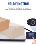 Heavy Duty Digital Shipping Scale With Durable Stainless Steel Deck And Rock Solid 396 Pound Capacity shows hold function with package on scale.