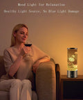 Woman relaxing with a Jellyfish Lamp With 16 Color Changing Lights And Remote Control on a side table, ambient night lighting.