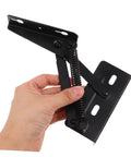 Hand holding spring loaded sofa hinge kit for easy installation in furniture.