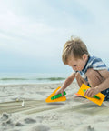 Child playing with 7 Piece Beach Sand Toys Set With Buckets Shovels Rakes And Castle Sand Molds For Kids Bright And Kid Friendly Beach Accessories