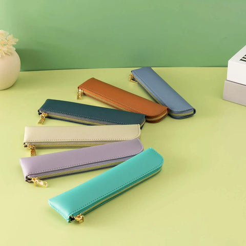 Assorted leather pencil cases with zippers, including Purple Leather Pencil Case For Adults Slim Soft Pen Bag With Zipper Minimalist Pencil Pouch Premium Leather Craft For Pros Ultra Lightweight Office And School Storage For Notes Drafts And Everyday Carry, arranged on green surface.