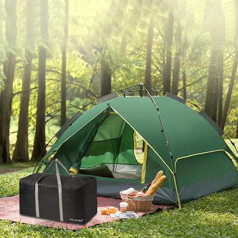 Black Ultra Spacious 96L Travel Duffle Bag next to green tent in forest setting, emphasizing camping use.