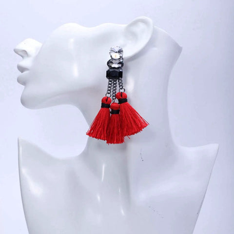 Red tassel earrings with black accents on a mannequin head, side view