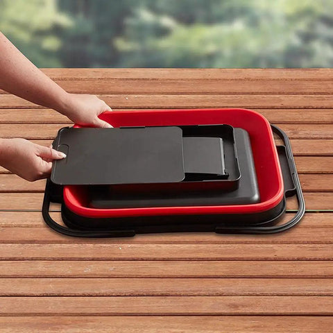 Collapsible Caddy Tote with fold down handles and removable section for customizable storage in red and black on wood table.
