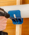 Heavy Duty Dust Hose Support Cradles For 4 Inch Shop Vac Tubing, blue ABS mounting bracket securing a PVC pipe to the wall.