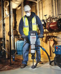 Worker using Beefy 20 Inch Narrow Chisel For 1-1/8 Inch Hex Breaker Hammers, Steel Point And Chisel For Concrete Hole Starters in basement.