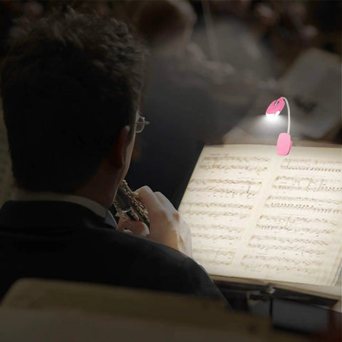 Musician using a Kids Clip On Reading Light 3 Pack Battery Operated Dimmable Lamp With 12 CR2016 Batteries Included Flexible 360 Degree Neck For Bedtime Reading Kid Friendly LED Low Heat Soft Light For Cozy Nights In Bed to illuminate sheet music during a performance