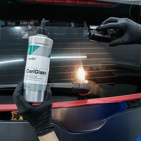 CeriGlass Glass Polish And Cleaner Compound For Auto Glass Restoration 500ml 17oz Removes Swirls Light Scratches Water Spots Tiny Pits And Wiper Grime With Dual Action Machine For Crystal Clear Windshield bottle held beside rear windshield