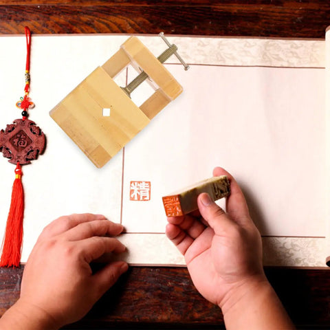 Adjustable Wood Carving Tool Clamp for Engraving and Seal Carving on paper with a hand holding a carved seal block