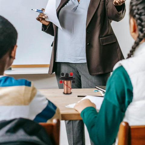 Teacher demonstrating Hands On Electromagnetic Induction Solenoid Kit For High School Physics With Primary And Secondary Coils.