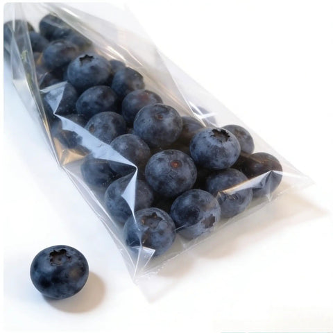 Hassle Free Compact Horizontal Flow Packager And Slick Shrink Wrapping Machine Cranking Fifty To Eighty Packages Per Minute For Bakeries Fresh Markets And Smooth Home Business Setups with blueberries in a clear bag.