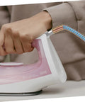 Close-up of a person using an iron with a High Temperature Steam Hose Replacement Tube For Steam Irons, Heavy Duty High Pressure Design.