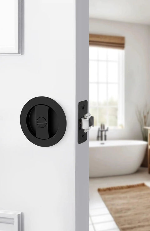 Matte Black Round Pocket Door Lock Set For Two One Eighth Inch Bore on white interior sliding door, bathroom background