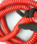 Straight Up Heavy Duty Stretch Coiled Extension Cord With Hella Tough Polyurethane Jacket and Flexible Spring Design held in hand, showing coiled red design.