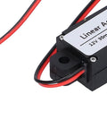 Close-up of the Compact 12V Mini Electric Linear Actuator with 30mm Stroke showing wires and label, 50N lift, for home automation projects.