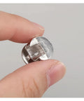 Close-up of Heavy Duty Three In One Connector Eccentric Wheel Hardware, Nickel Plated Zinc Alloy, held between fingers.