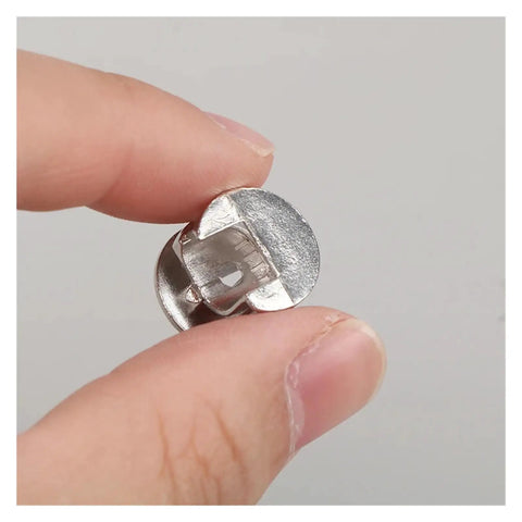 Close-up of Heavy Duty Three In One Connector Eccentric Wheel Hardware, Nickel Plated Zinc Alloy, held between fingers.