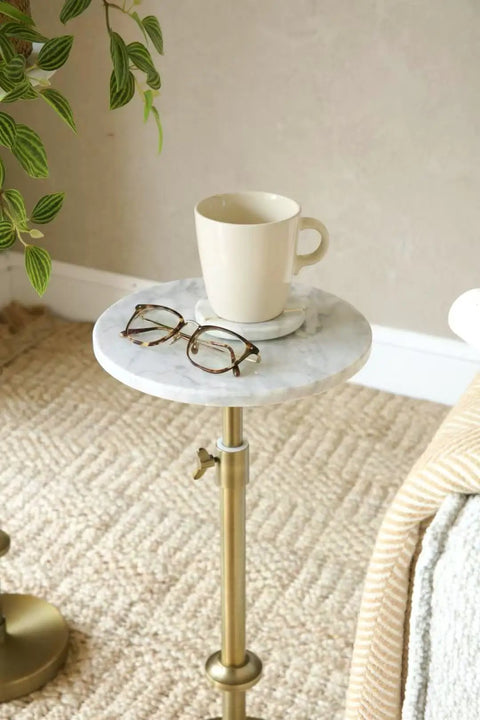 Adjustable Height Marble Drink Table With White Marble Top And Antique Brass Pedestal in cozy living space with mug and glasses