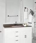 Kelton 4 Piece Matte Black And Satin Gold Bath Accessory Set installed in modern white bathroom, featuring towel bar and ring.