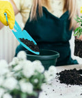 Person planting with blue trowel from Colorful Metal Garden Trowels Set Of 10 Hand Shovels For Kids Teens And Adults Built To Last Tough As Nails Tools For Soil Sand Planting And Sandboxes In Pink Red Blue Orange Green