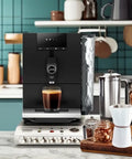 Step Up Your Home Brew Game With This Compact Automatic Coffee Machine Featuring A Pro Aroma Grinder And Super Simple Programmable Settings In Classic Metropolitan Black Color, with cup of espresso.
